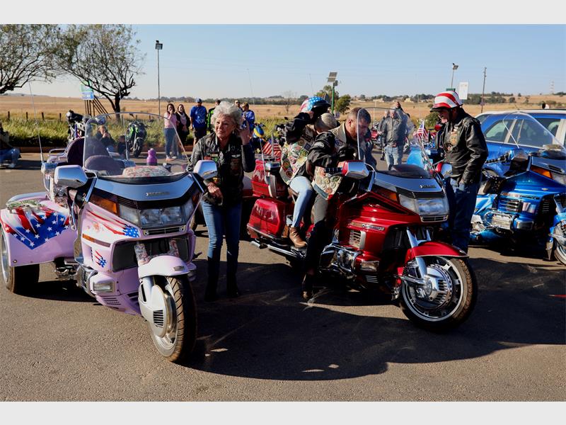 A group of people on motorcycles with side cars.
