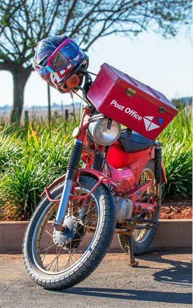 A red motorcycle with a box on the back.