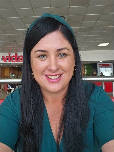 A woman with long black hair and a green shirt.