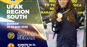 A girl holding a medal and standing next to a banner that says ufak region south.