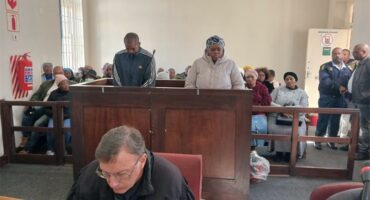 People in court sitting in a courtroom with a judge.
