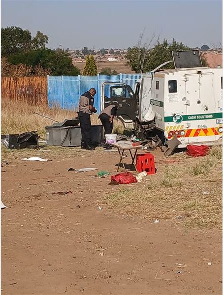 A man standing next to a truck and a trash can.