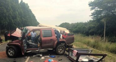 A car is overturned on the side of the road.
