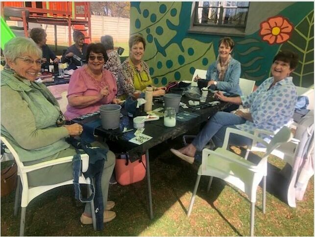 A group of women sitting at a table with their phones.