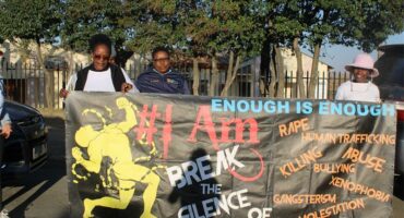 A group of people holding a banner that says enough is enough.