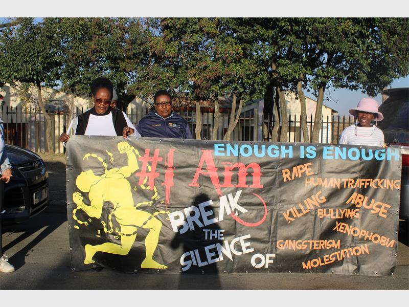 A group of people holding a banner that says enough is enough.