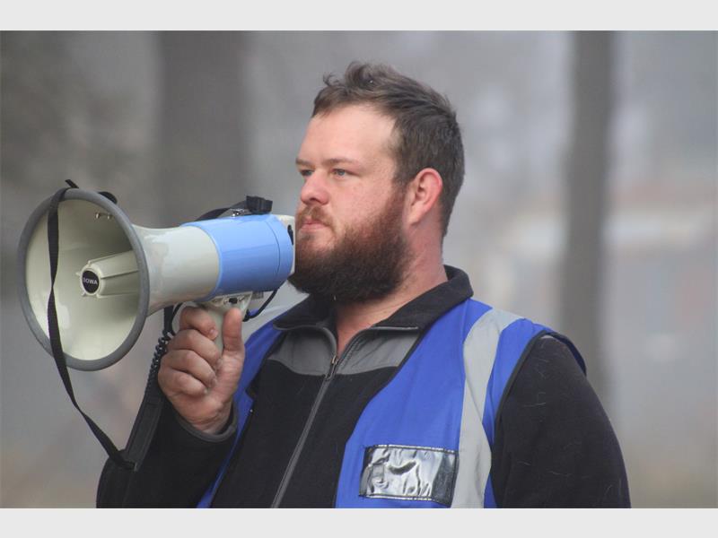 A man with a megaphone in the woods.