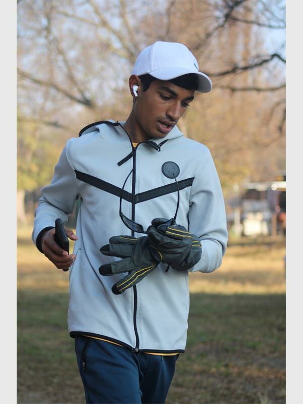 A man wearing gloves and a hat is running.