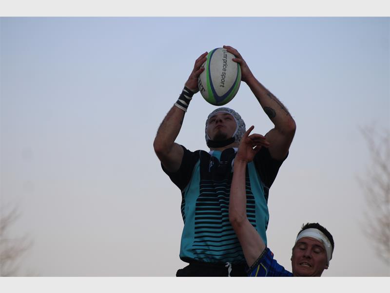 A man is holding a rugby ball in the air.