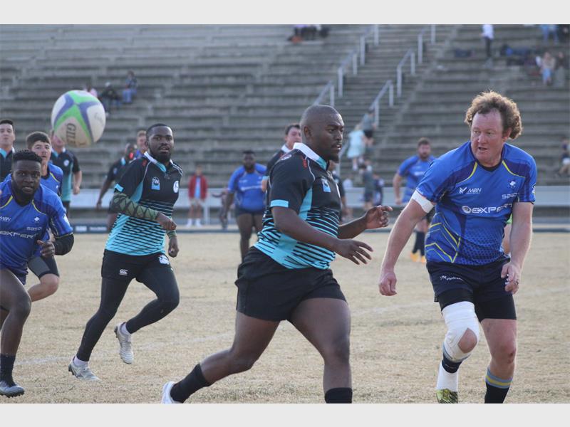 Rugby players in blue and black jerseys playing a game.