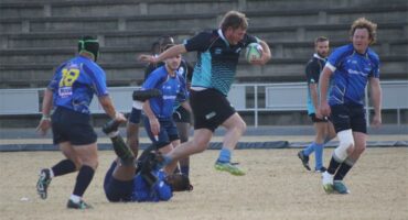 A rugby player is running with the ball.
