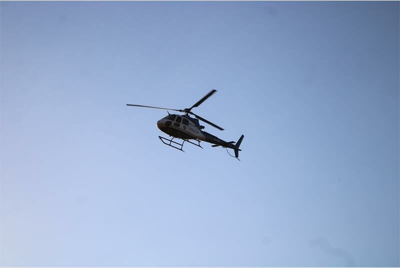 A helicopter flying in the sky with a person on it.