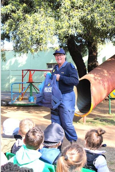 A man in blue uniform holding a bag of toys.