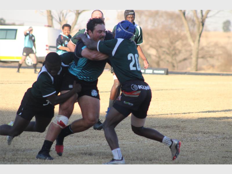 Rugby players are fighting for the ball in a game.