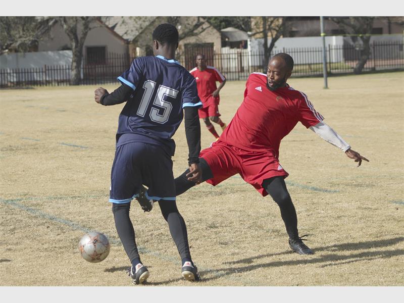 Two men playing soccer on a field.