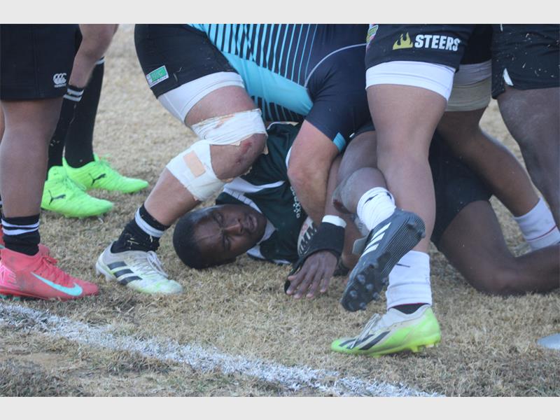 A rugby player is being tackled by other players.