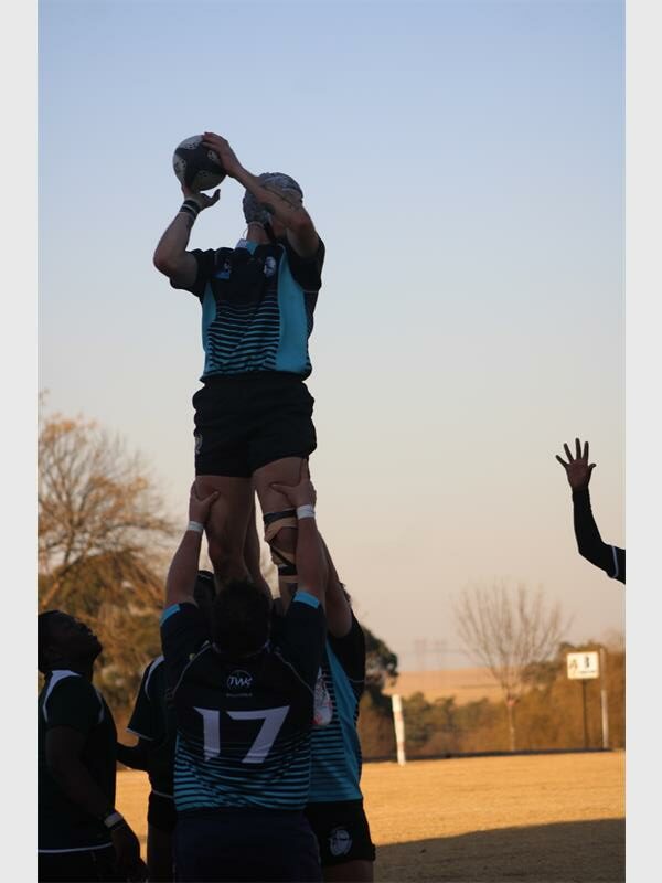 A man holding a rugby ball in the air.