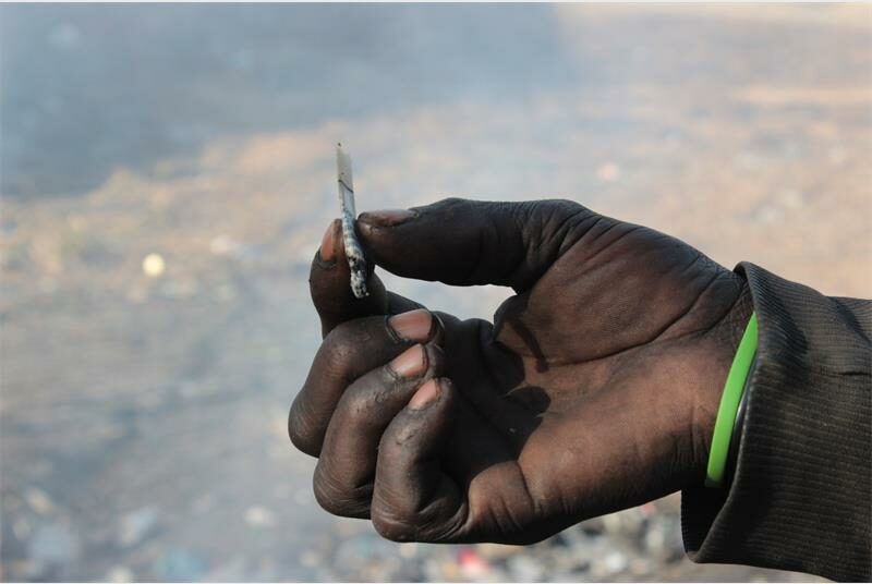 A man holding a cigarette in his hand.