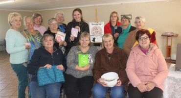 A group of women holding up their books.