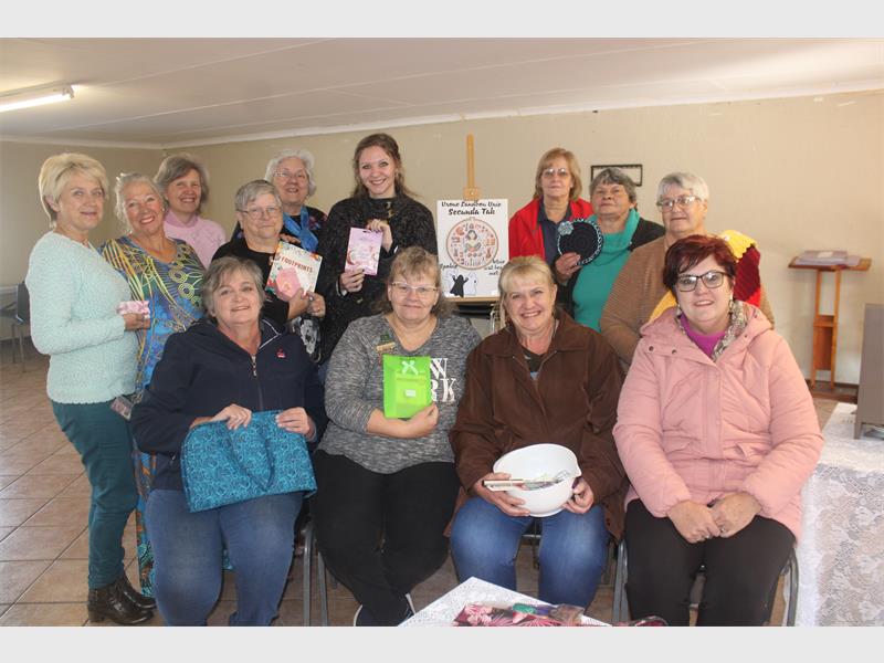 A group of women holding up their books.