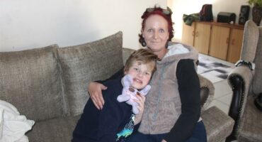 A woman and a child sitting on a couch.