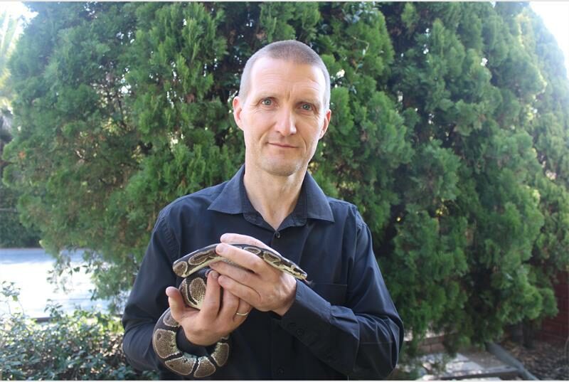A man holding a snake in his hands.