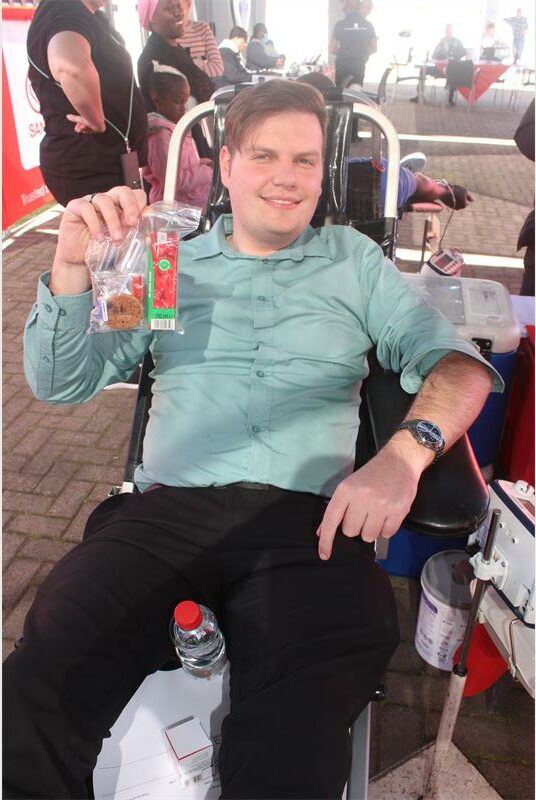 A man sitting in a chair holding a bag of chips.