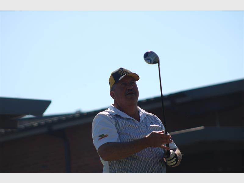 A man holding a golf club and swinging it.