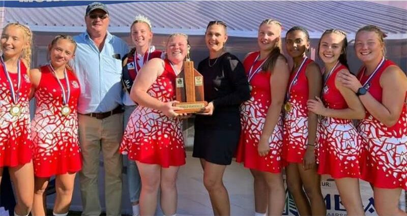 The girls tennis team poses for a photo with their trophy.