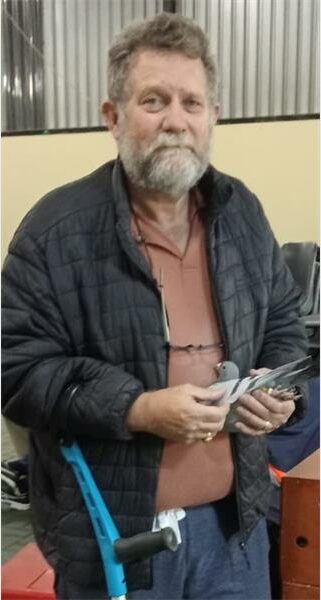 A man with a beard and glasses holding a dove.