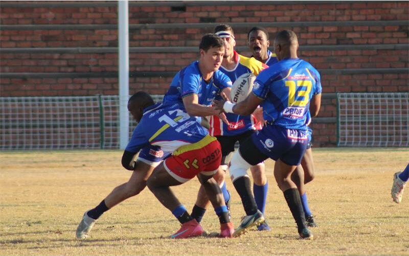 Rugby players in action on a field.