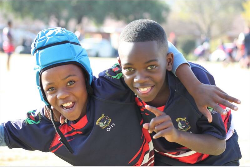 Two young boys are smiling and posing for a photo.
