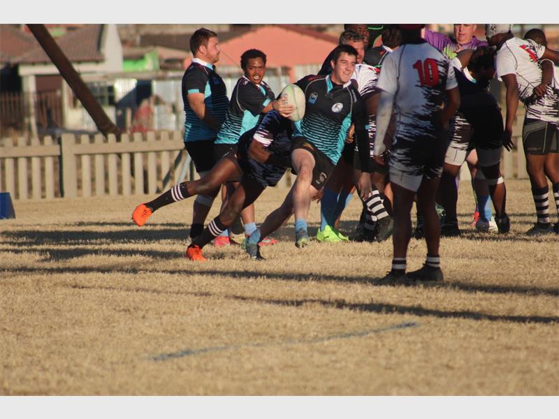A group of men playing rugby on a field.
