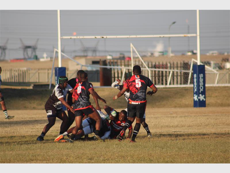 Rugby players in action on a field.