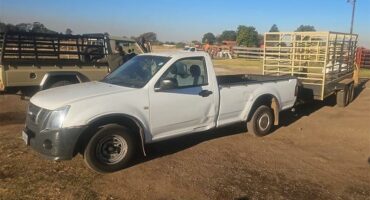A white truck with a trailer attached to it.