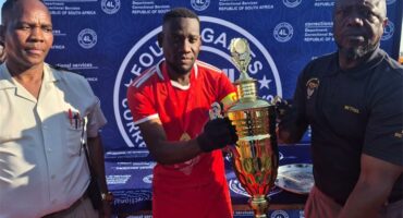 Two men holding a trophy and standing next to each other.
