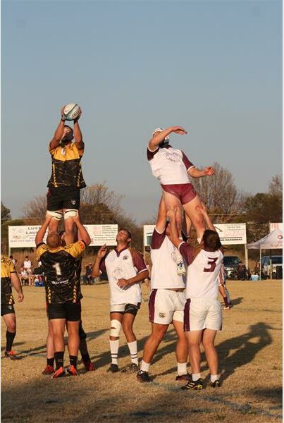 A group of men playing rugby in the field.