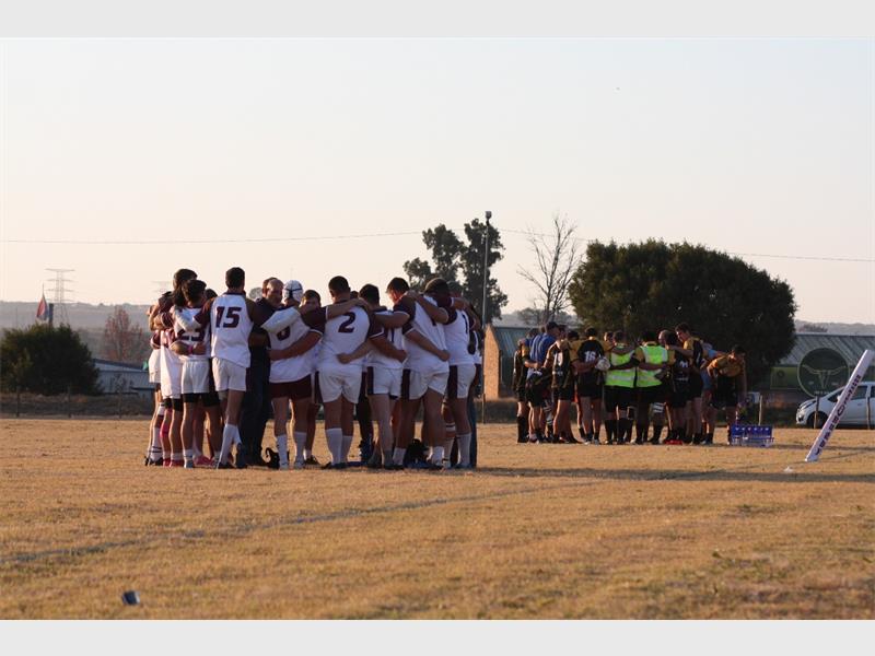 A group of people huddle together on a field.