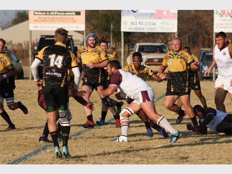 A rugby player is trying to get the ball away from the other players.