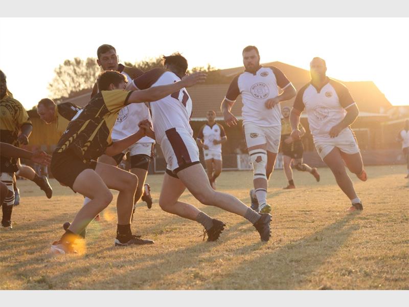 A group of men playing rugby on a field.