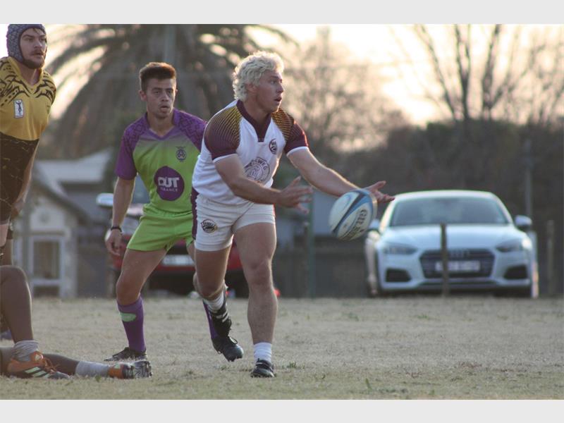 A rugby player is about to pass the ball.