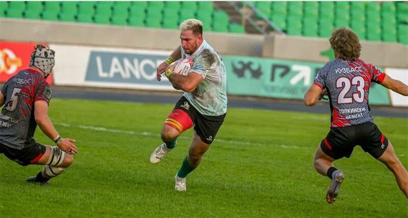A rugby player is running with the ball.