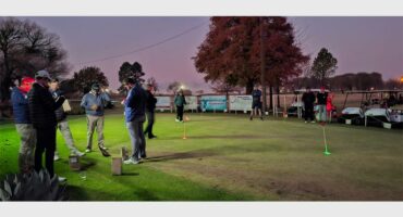 People playing golf at night in a park.