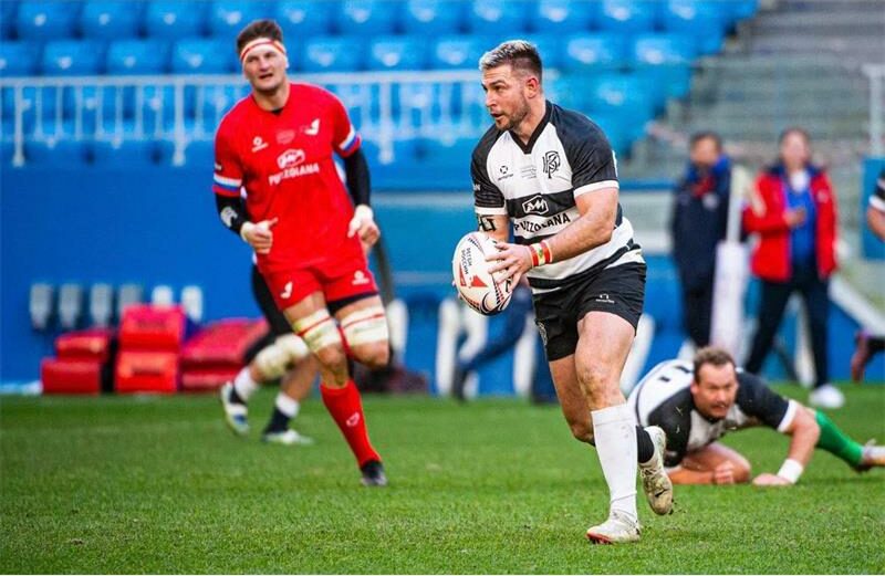 A rugby player is running with the ball.