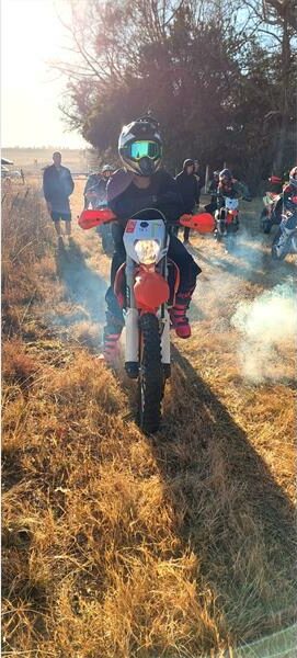 A person riding a dirt bike in a field.