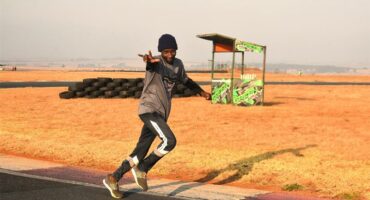 A man is running on a track in the middle of a field.