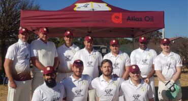 A group of men in white shirts and red caps.