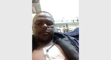 A man in a hospital bed with an iv tube.