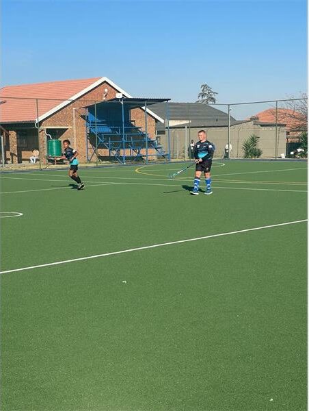 A group of people playing a game of field hockey.