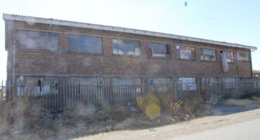 An old building with a lot of windows and a fence.